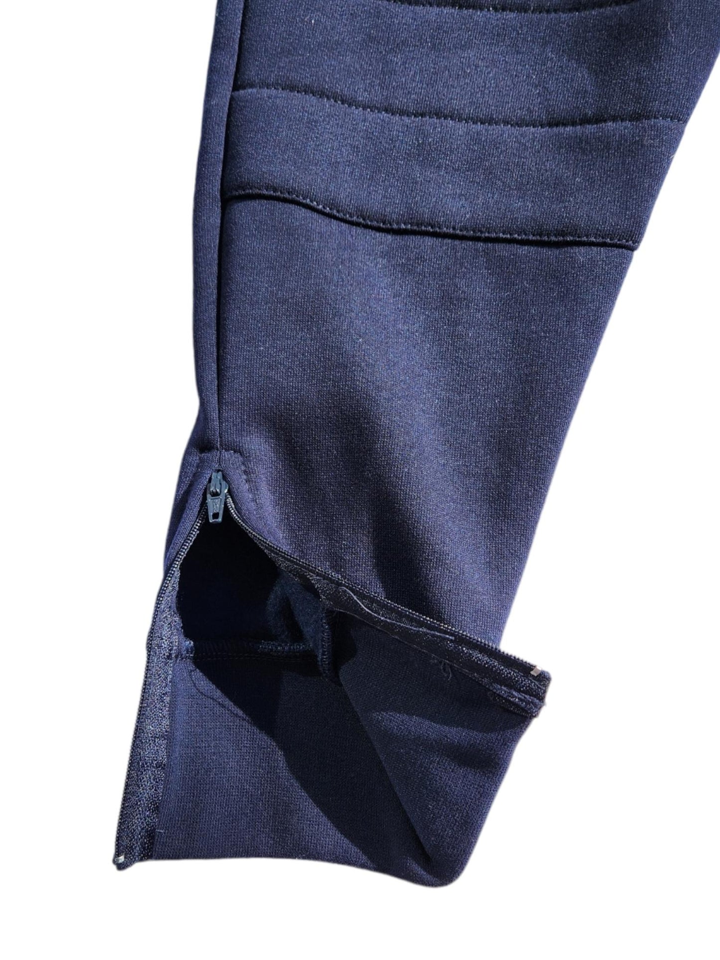 Close up image of navy blue school cotton fleece track pants with zip open at the ankle portion